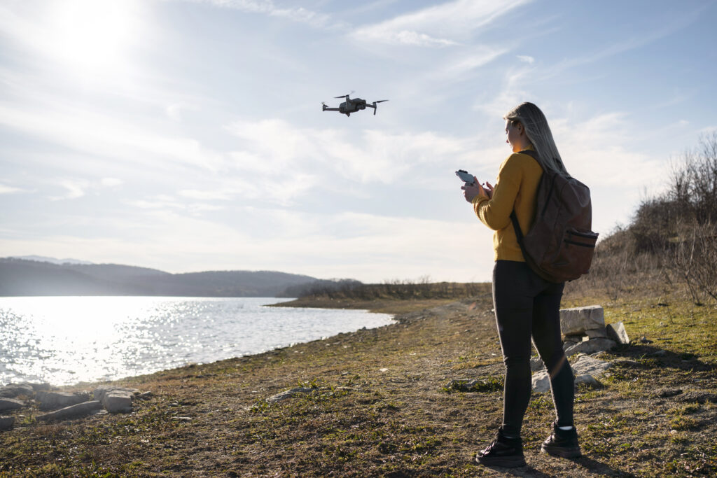 Mujer controlando un dron en medio rural