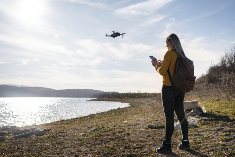 Mujer controlando un dron en medio rural